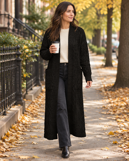 Black cable-knit maxi cardigan styled for a fall walk with coffee on a tree-lined street