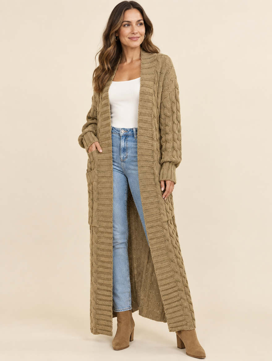 Woman wearing the Maren khaki cable-knit maxi cardigan with a white tank and jeans