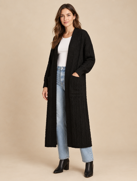 Woman wearing the Maren black cable-knit maxi cardigan open over a white tee and light-wash jeans
