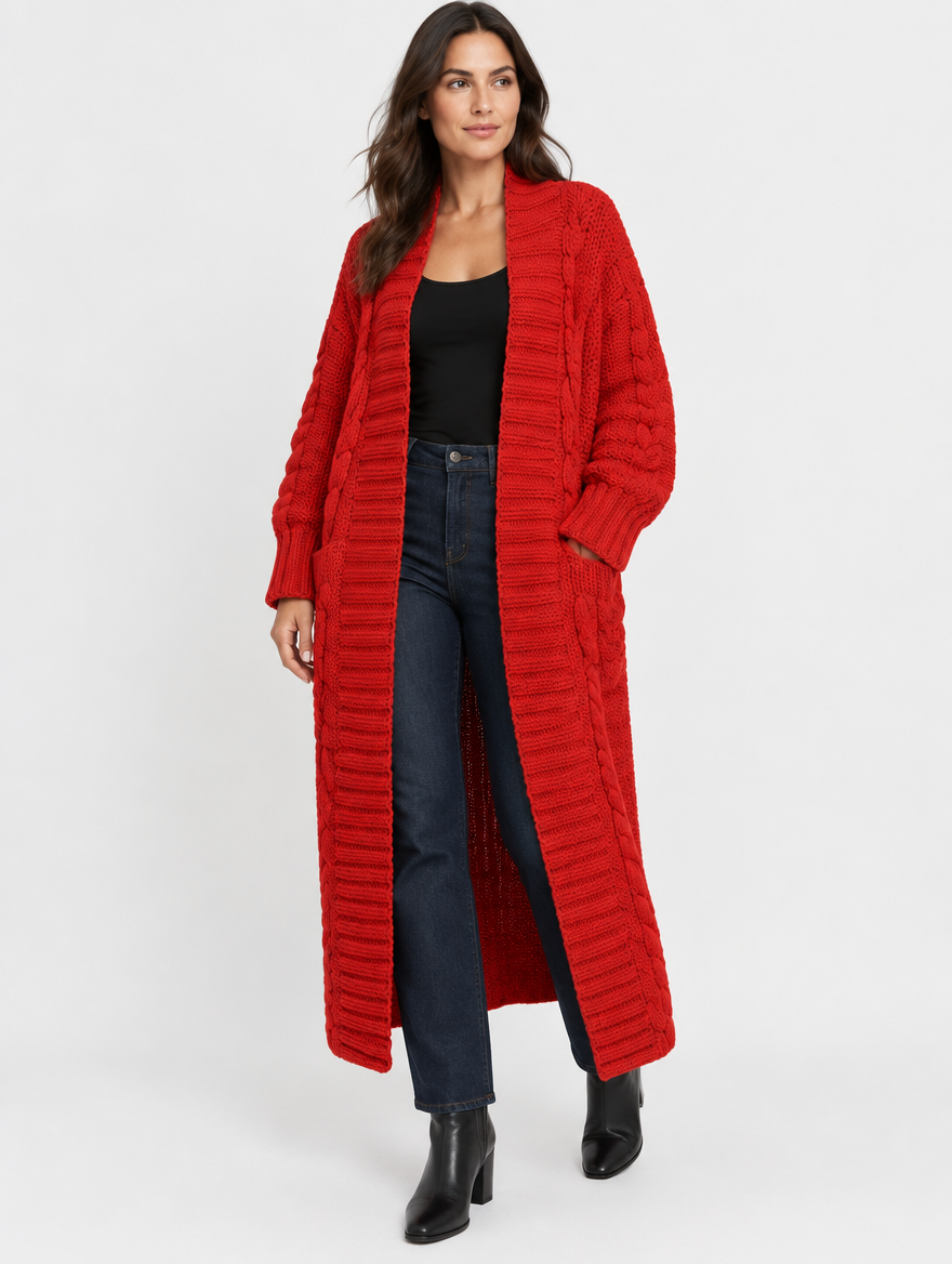 Woman wearing the Maren red chunky cable-knit maxi cardigan over a black tank and dark jeans